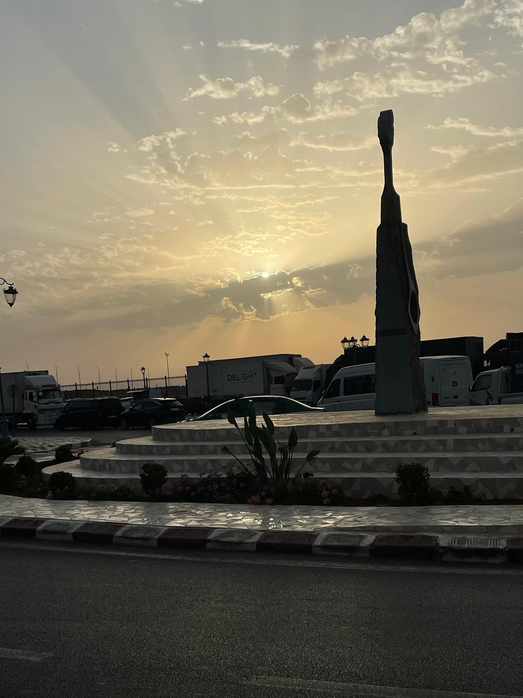 La sculpture du rond-point à contre-jour, ciel doré